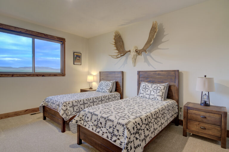 Bedroom with two beds and antler decor at Montana Skies in Livingston, Montana