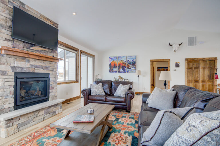 Living room with stone fireplace and TV at Montana Skies vacation rental in Livingston, MT