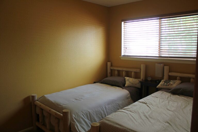 Bedroom with two twin log beds at the Madison Guest House in Bozeman