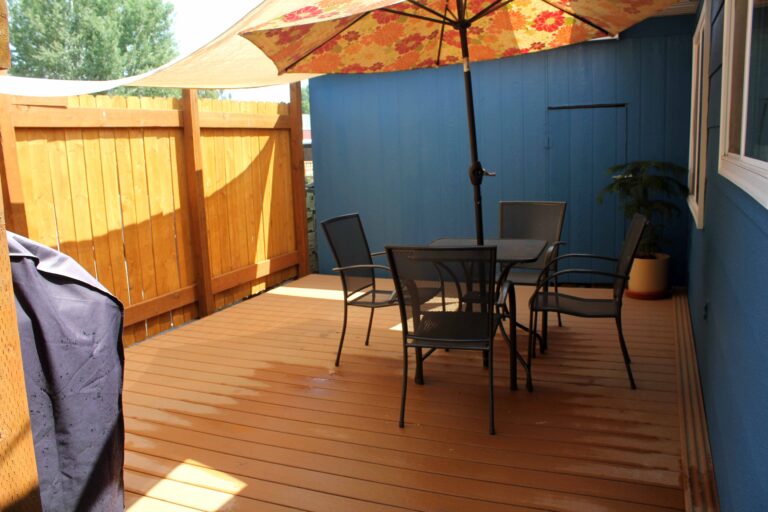 Private deck with umbrella and outdoor dining at the Madison Guest House in Bozeman