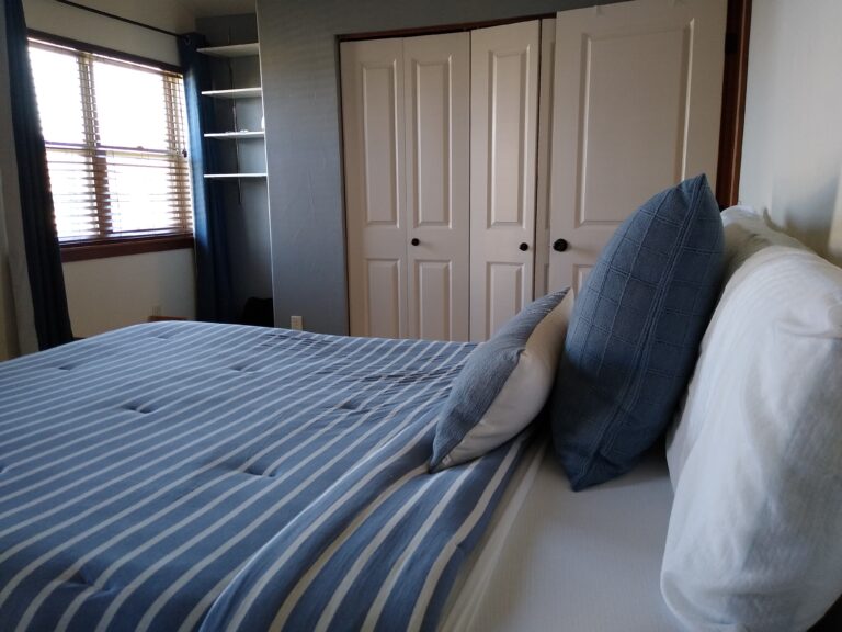 Bedroom with blue bedding and closet at the Northside Condo in Bozeman