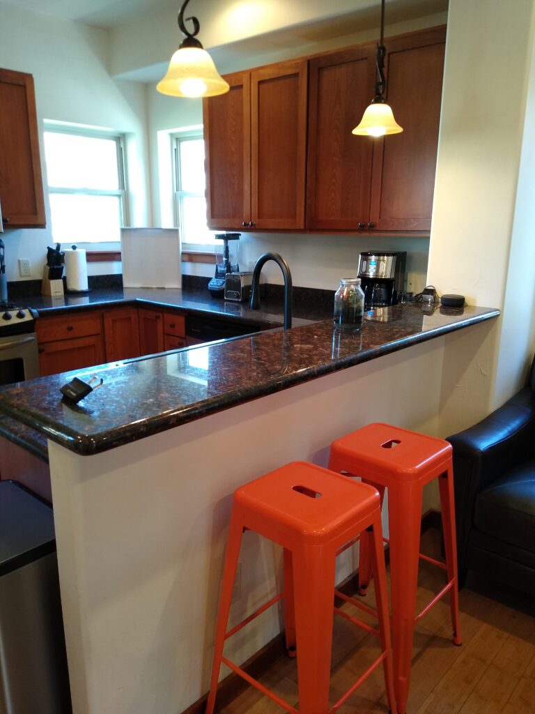 Kitchen breakfast bar with orange stools at the Northside Condo in Bozeman