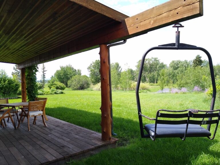 Covered porch with chairlift swing at the Gallatin River Cabin, Montana