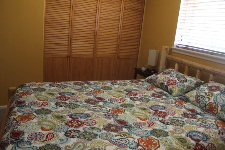 Bedroom with log bed frame at the Madison Guest House in Bozeman, MT