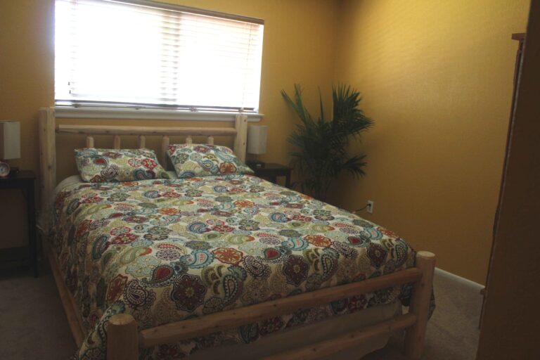 Sunny bedroom with log bed at the Madison Guest House vacation rental in Bozeman, MT