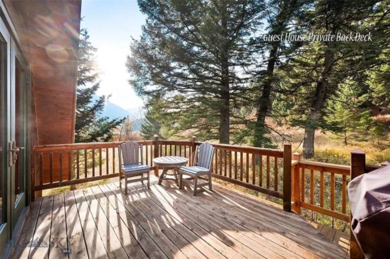 Sunny deck with pine forest views at the Flying J Bunkhouse, a Montana vacation rental